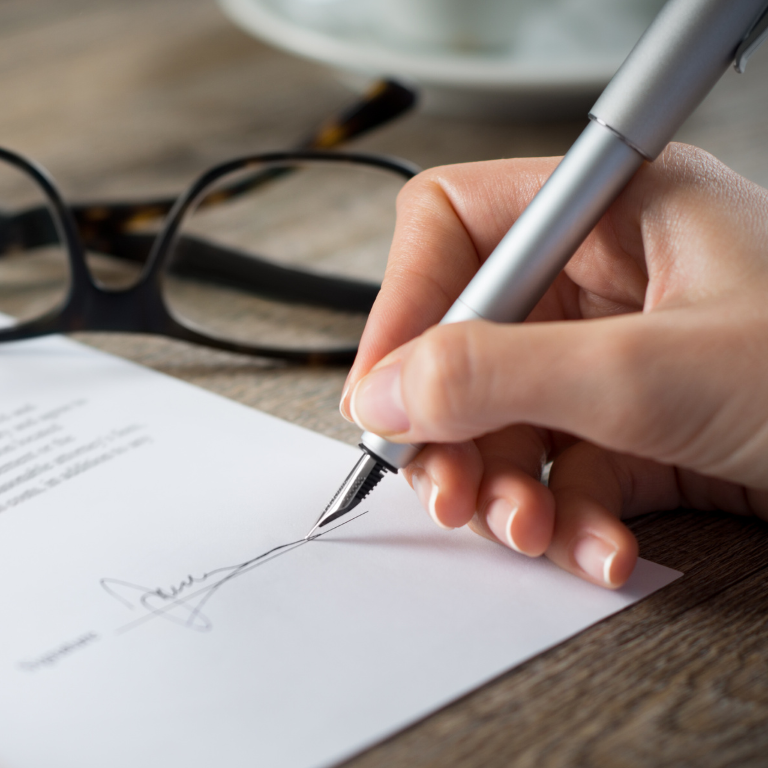 Close up of a hand signing a document